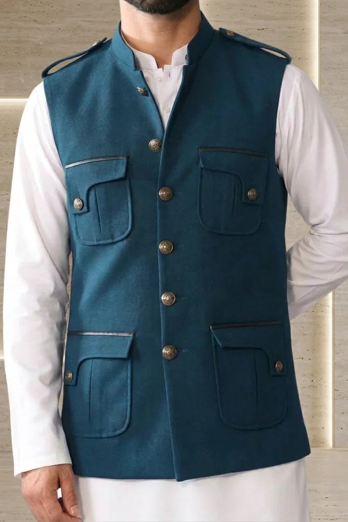 Button-flap patch pocket detail on peacock blue tweed koti with contrast piping